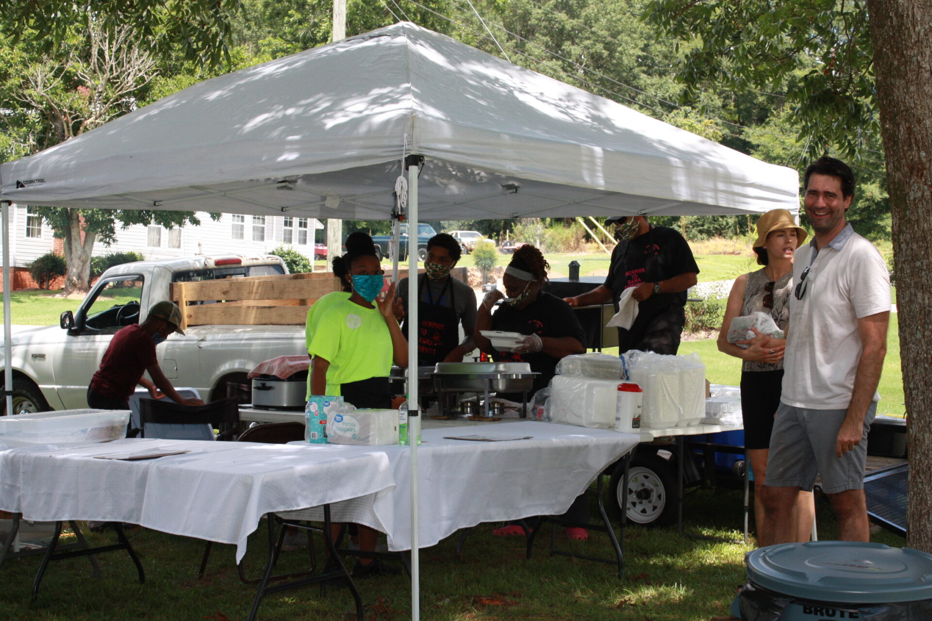 People standing by a table at an event at Pennington Park