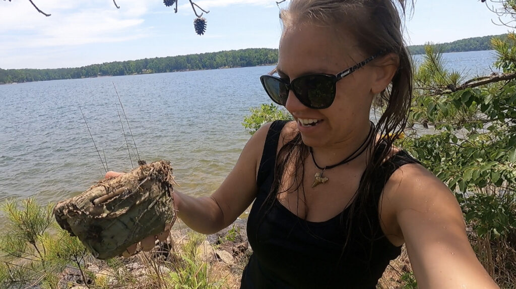 girl by lake with geocache container 