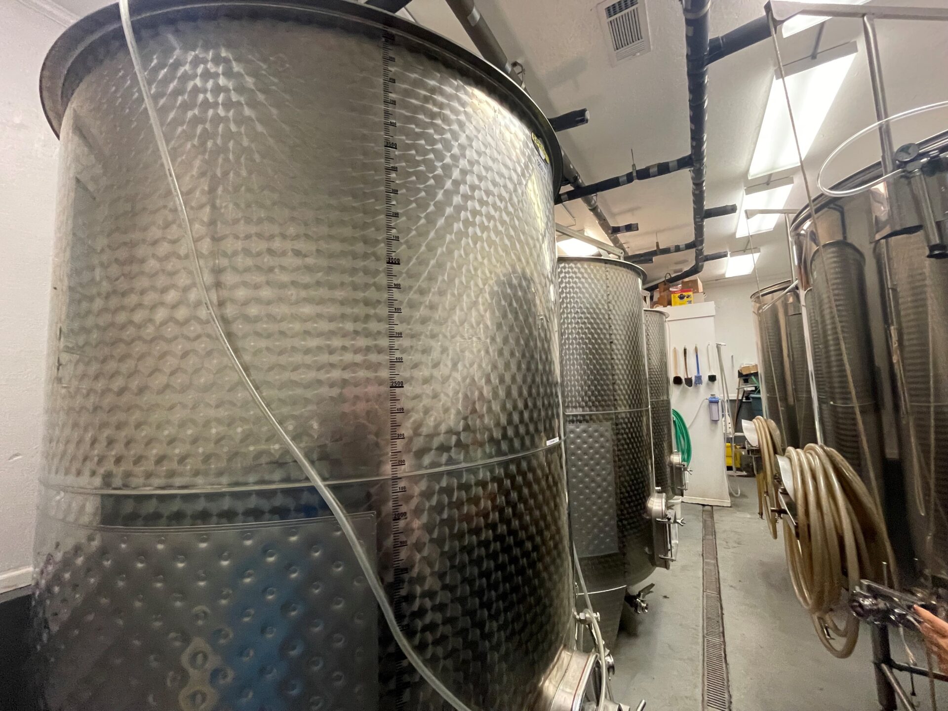 big storage containers of wine fermenting 