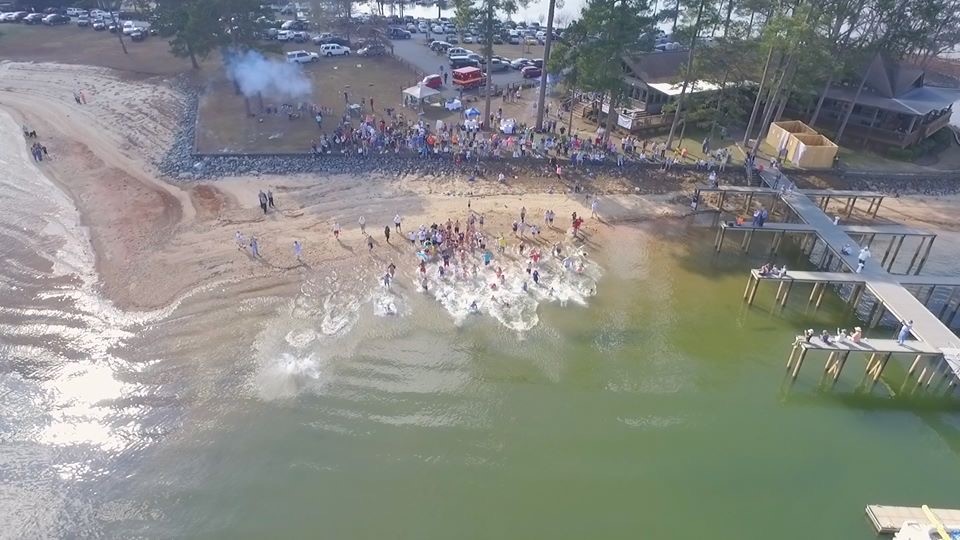 people running in the water at the polar plunge