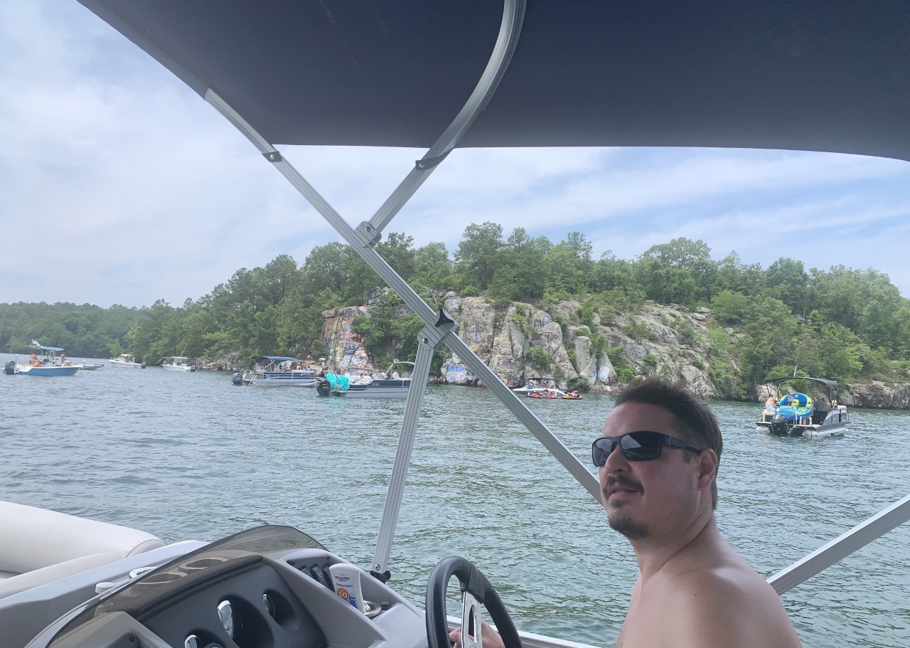 man driving boat near chimney rock