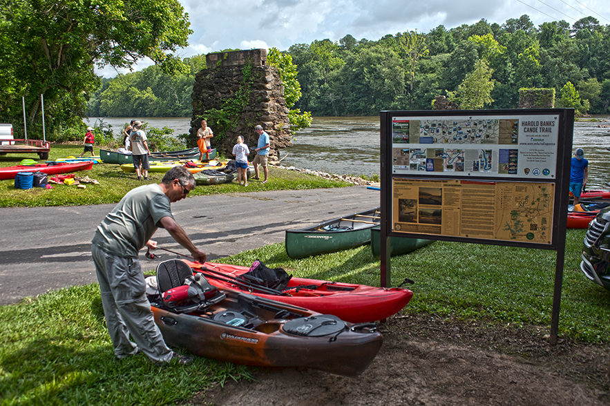 people and kayaks by water