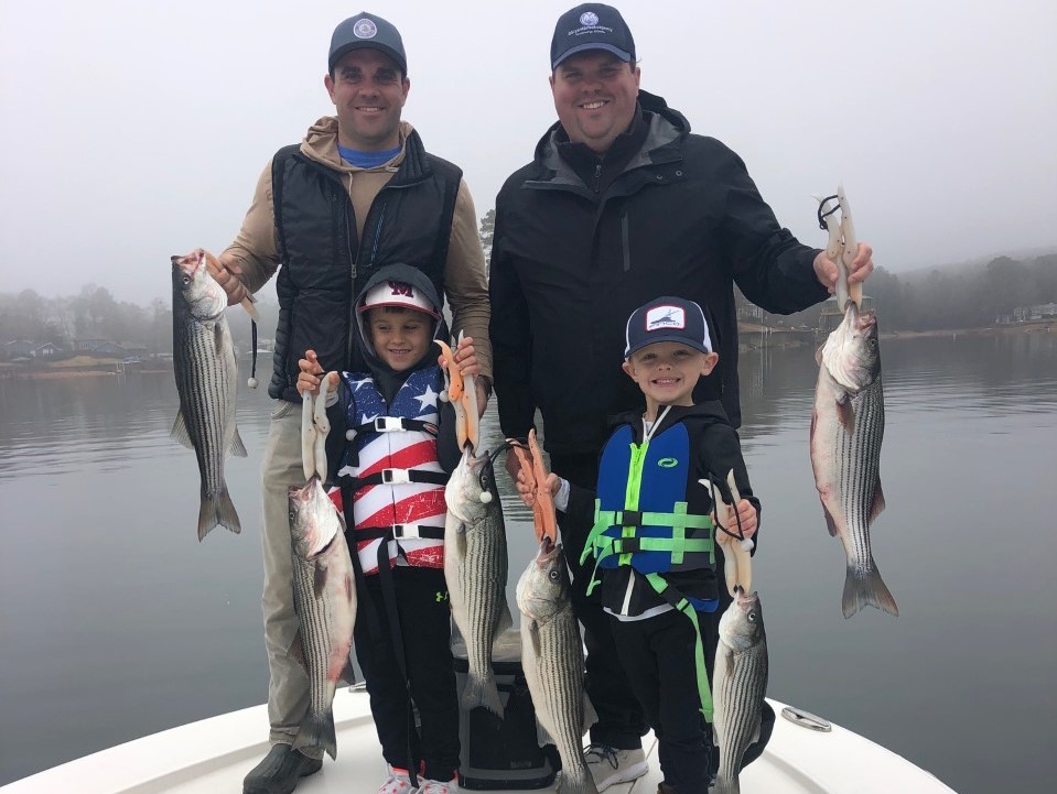 men and kids holding fish