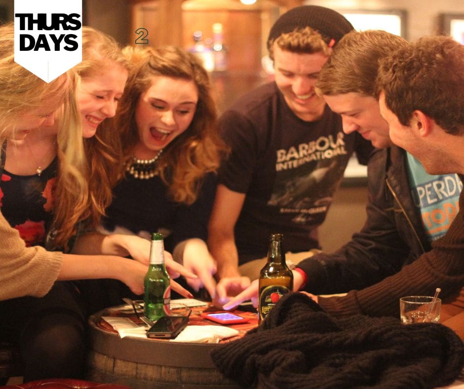 Group of men and women laughing and drinks on table