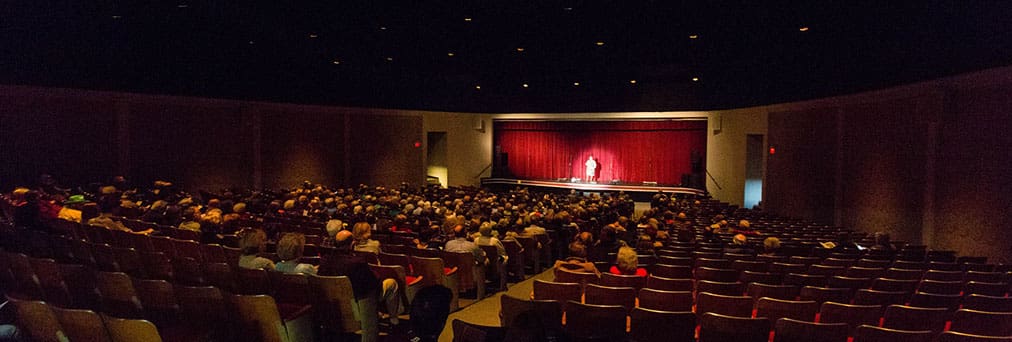 a man performing on the stage in a theater