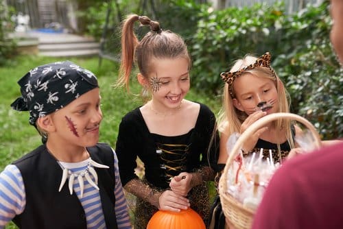 children dressed in costumes playing trick or treat