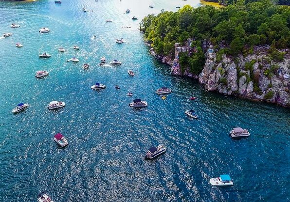 Cluster of boats on a lake, near a dramatic bluff