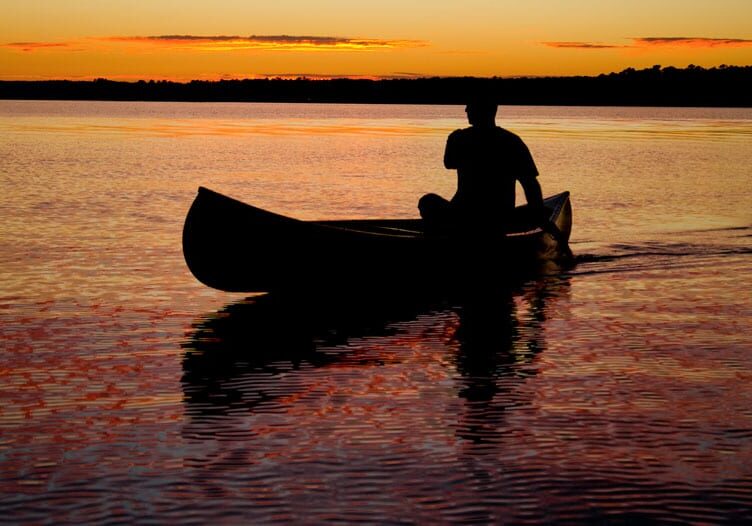 Silhouette of a paddler in a canoe