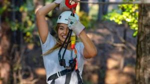 A smiling woman swings on a zipline