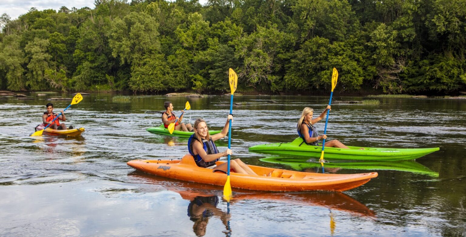 A group of kayakers head down a river