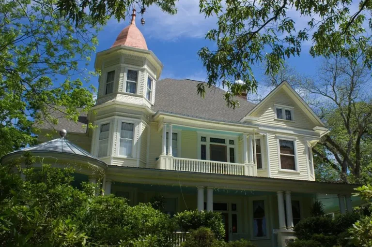 Exterior of a grand Bed & Breakfast building, with a peaked roof and yellow walls