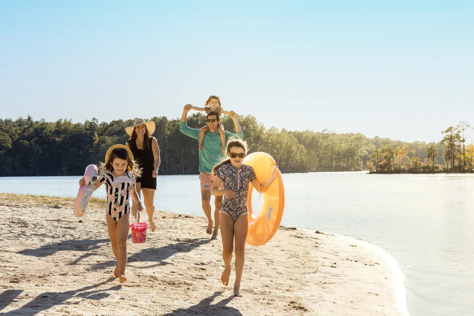 A family run down a sunny beach