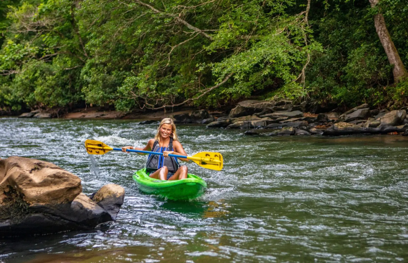 A woman in a kayak approaches the shore