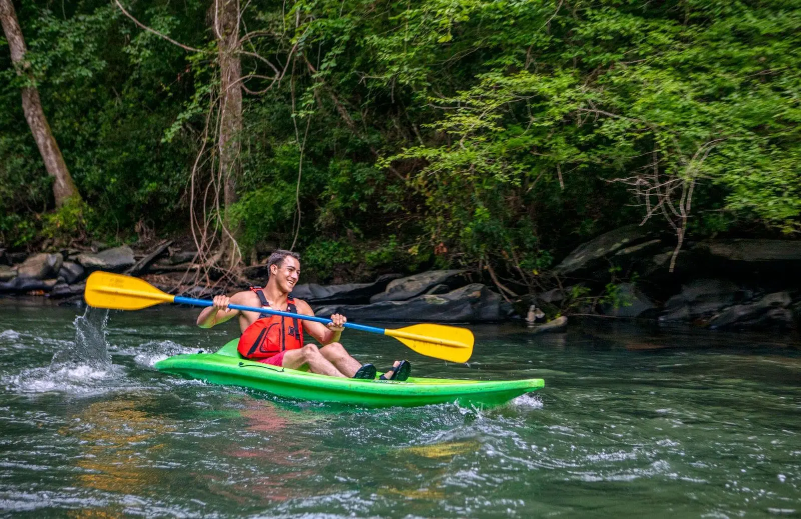 A man in a kayak negotiates a fast-moving stretch of river