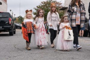 A group of kids in costume trick or treating