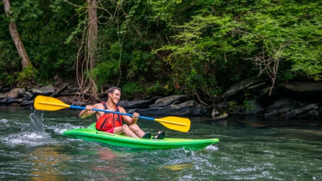 A man in a kayak negotiates a fast-moving stretch of river